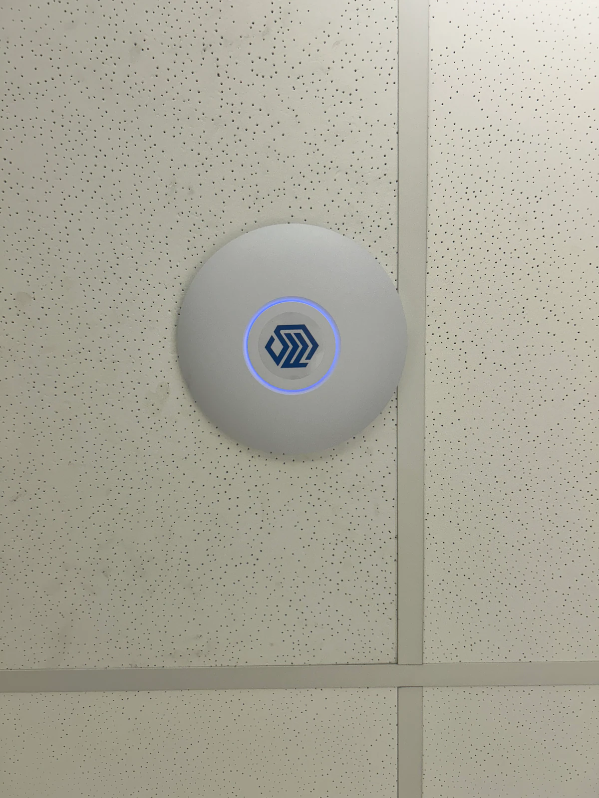 Ponto de acesso instalado em forro, com identificação visual da System Frame.